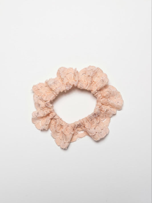 Pink lace scrunchie on a white background