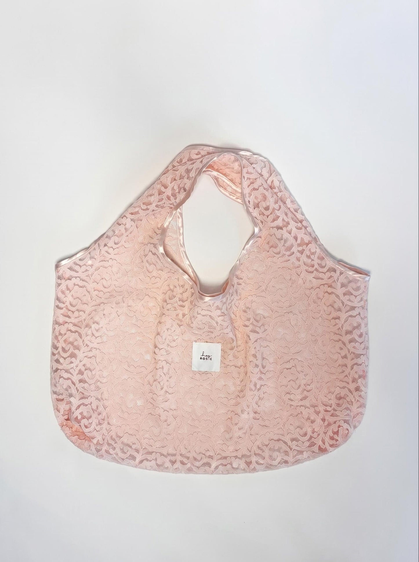 Pink lace handbag with a visible brand logo on a white background
