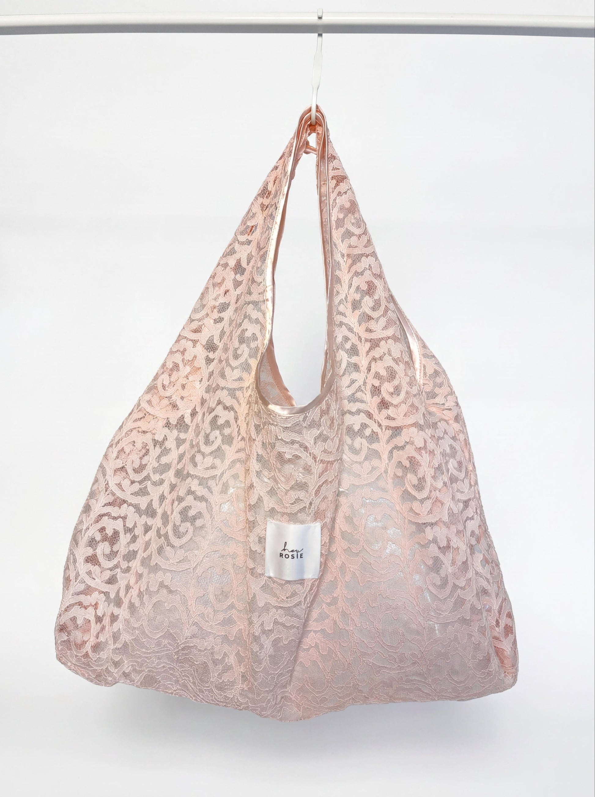 Pink lace bag with a visible brand label on a white background